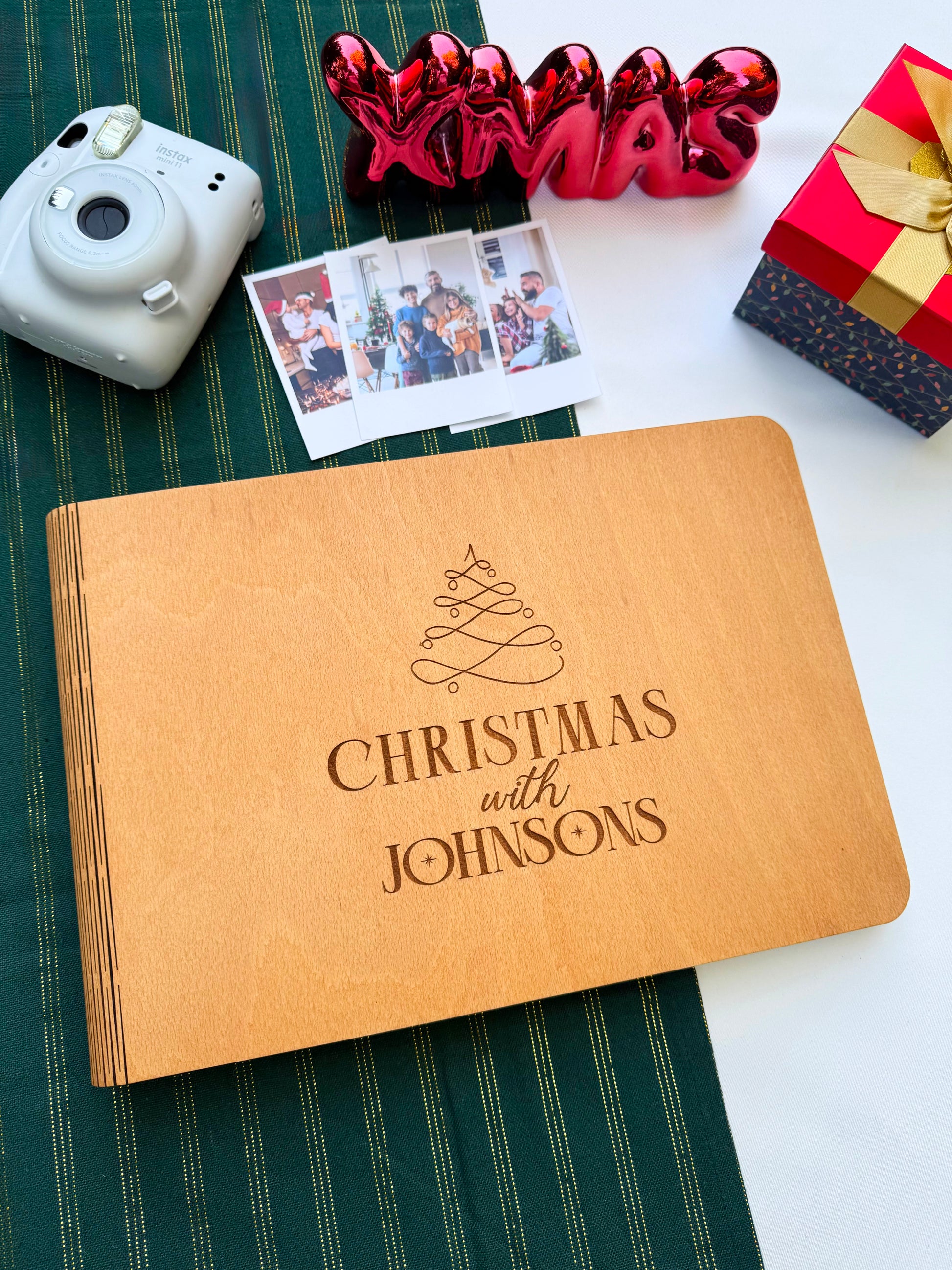 Close-up of engraved wooden Christmas album cover with family name.