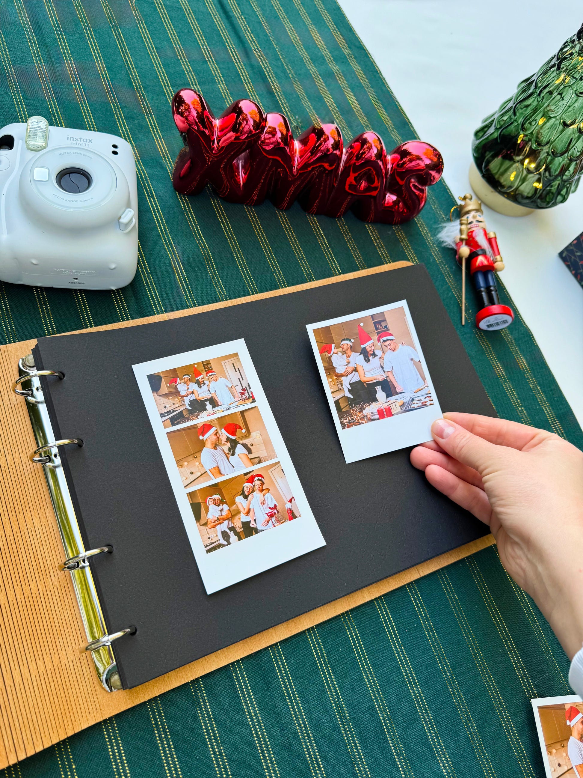 Album with Christmas-themed photos and decorations on a green surface